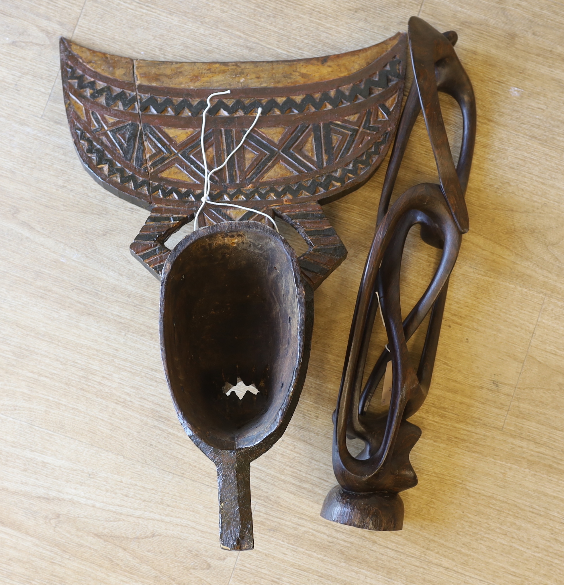 An African carved wood mask and a similar sculpture, 61cm high